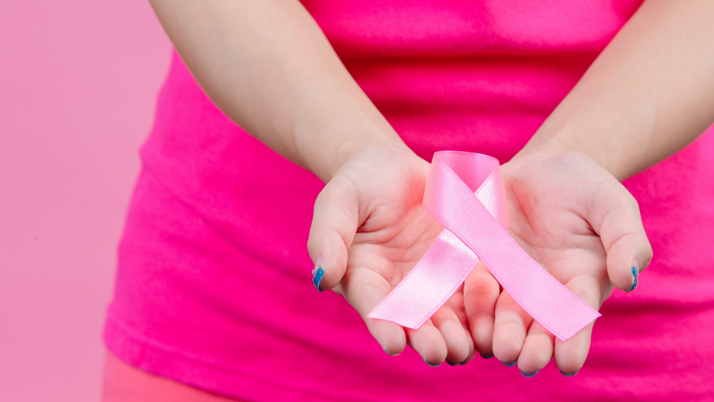 Breast cancer awareness month, pink ribbon placed on both hands of women Is a symbol for World Breast Cancer Day. In October.