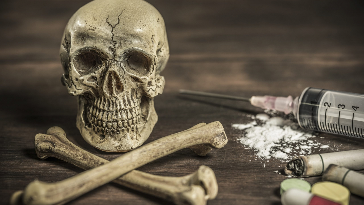 Human skull and crossbones with drug addict, healthcare and medical drugs addition concept