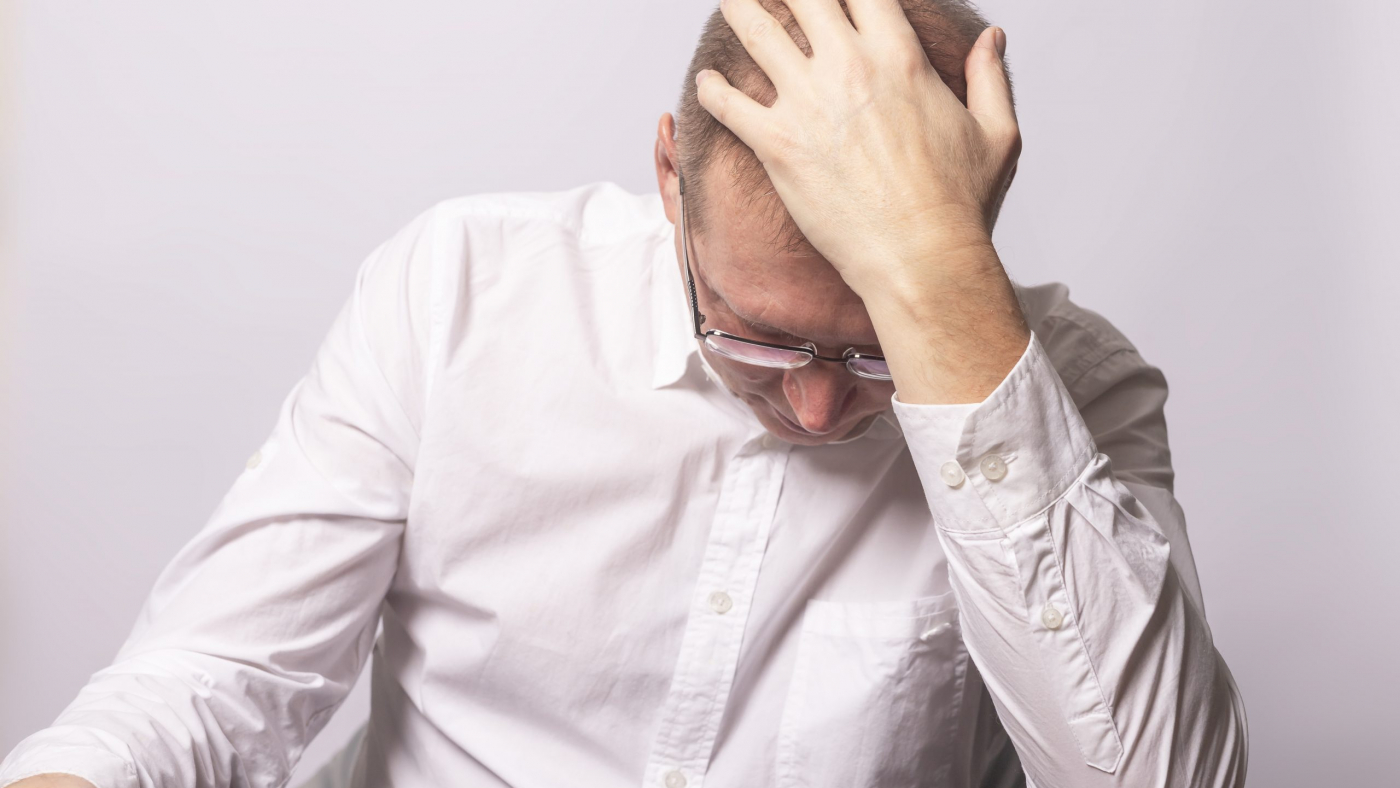 Depressed businessman in anxiety with hand on head. Tired man in panic. Worrying human.