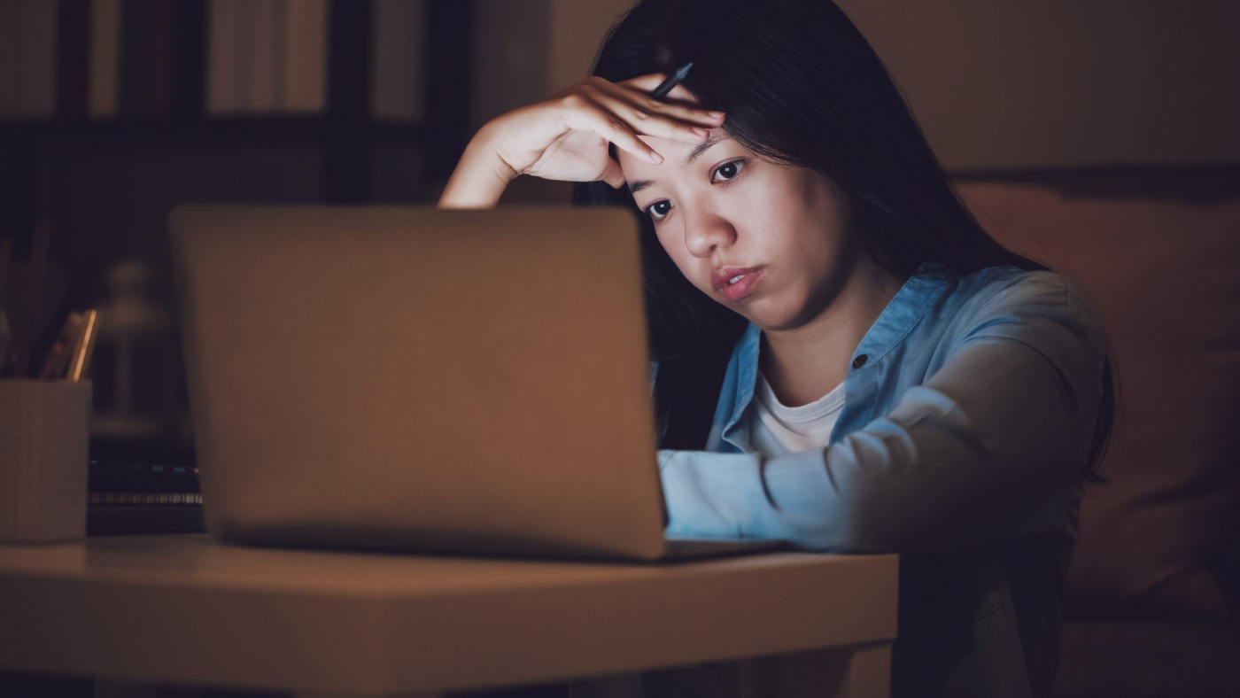 Asian woman student or businesswoman work late at night. Concentrated and feel sleepy at the desk in dark room with laptop or notebook.Concept of people workhard and burnout syndrome.
