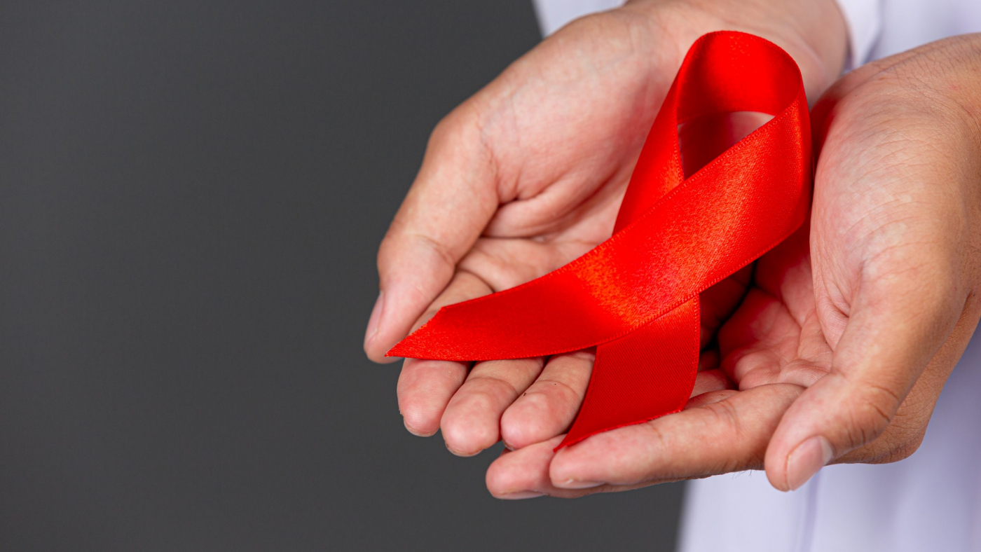 The doctor holds a red ribbon, HIV awareness awareness, World AIDS Day and World Sexual Health Day.