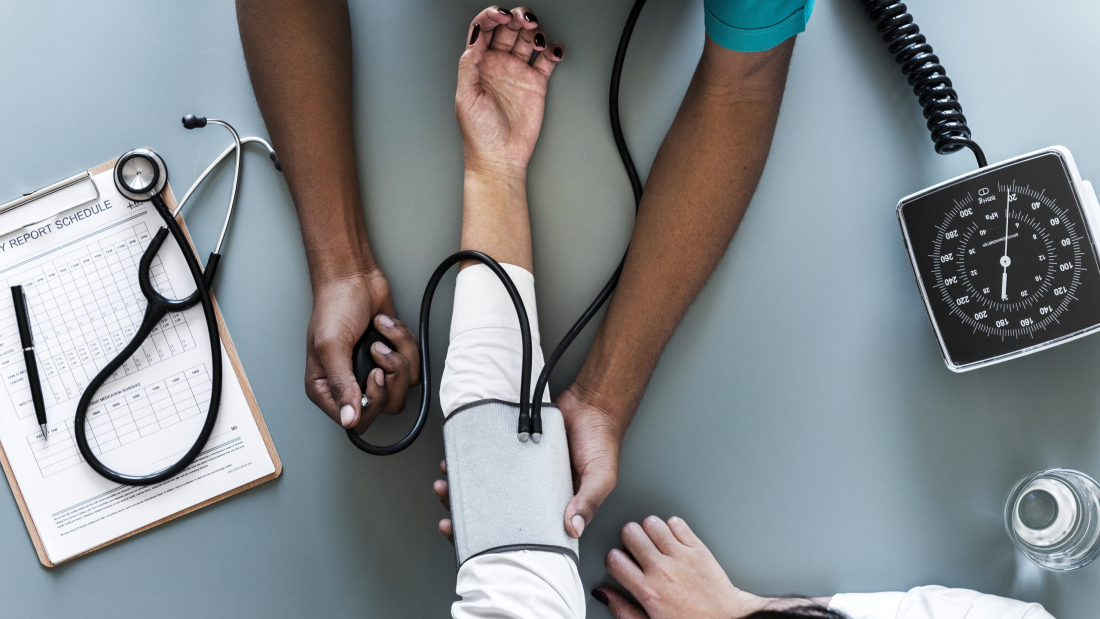 Enfermera midiendo la tensión arterial de un paciente