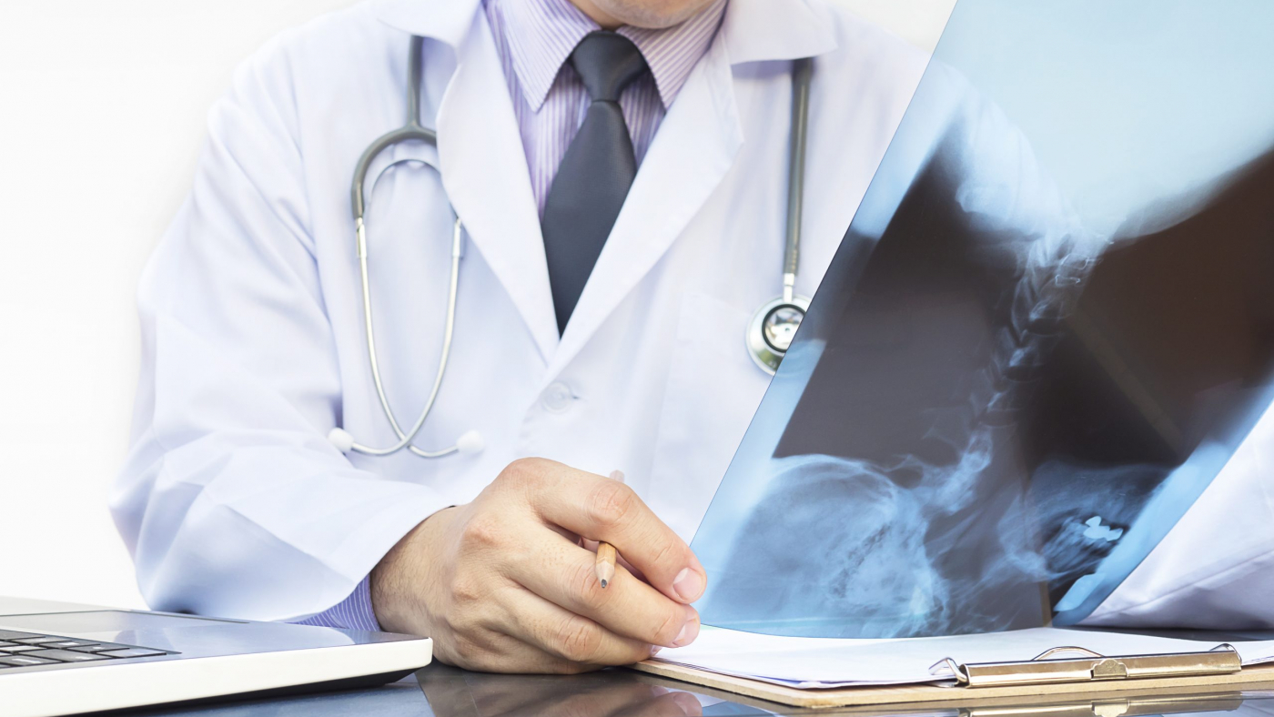 Doctor examine x-ray film over white background