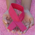 Breast Cancer Awareness Pink Ribbon in Hands Symbol