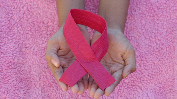 Breast Cancer Awareness Pink Ribbon in Hands Symbol