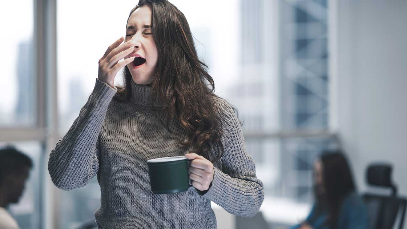 Caffeine Effects Woman Yawns from Fatigue Holding Coffee