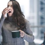 Caffeine Effects Woman Yawns from Fatigue Holding Coffee