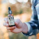 CBD Man Holds Bottle Photo