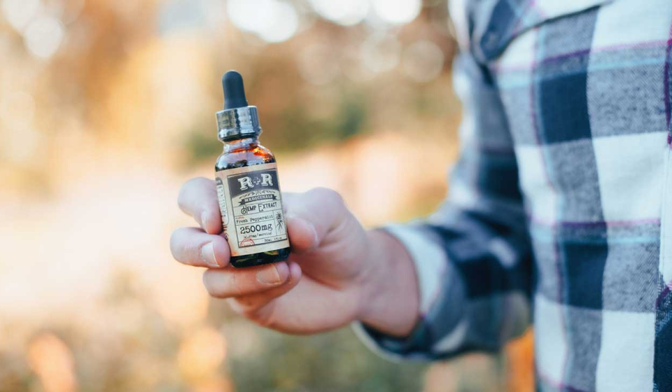 CBD Man Holds Bottle Photo