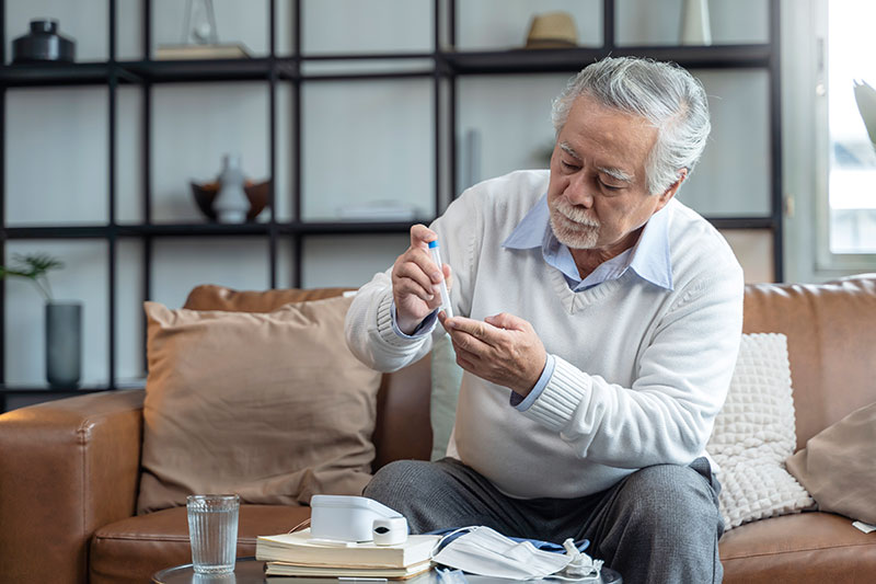 Diabetes Asian Man Tests Finger for Blood Sugar Level
