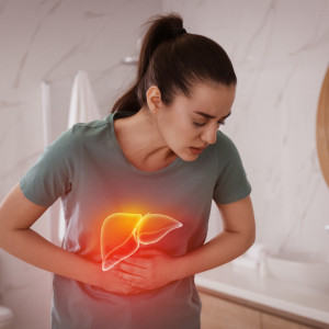 Sick woman suffering from pain in the bathroom and illustration of unhealthy liver.