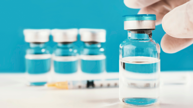 RSV Vaccine vials with a syringe on a blue background